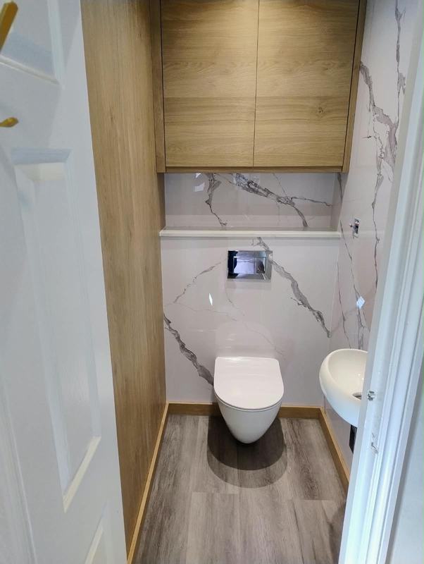 Finished WC with marble-effect tiles and oak cabinet