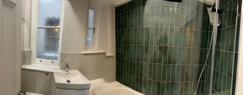 Bathroom with green wall tiles and new fittings