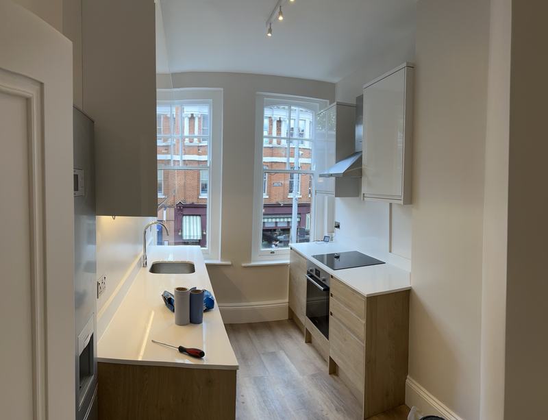 Kitchen installation with oak units and white worktops